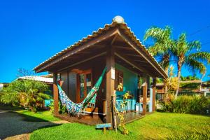 a house with a hammock in front of it at Sal Do Mar Cabanas Charme in Praia do Rosa