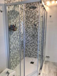 a shower with a glass door in a bathroom at Casa en el corazón de Gredos, amplia y agradable. in Navacepeda de Tormes +2 photos