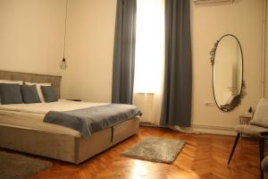 ein Schlafzimmer mit einem großen Bett und einem Spiegel in der Unterkunft Natalie's Royal M in Belgrad