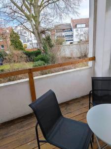 a black chair and a table on a balcony at Große Wohnung mit Balkon zentral in Osnabrück in Osnabrück