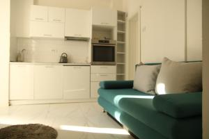 ein Wohnzimmer mit einem blauen Sofa und einer Küche in der Unterkunft Natalie's Royal M in Belgrad