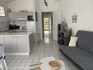 a living room with a couch and a kitchen at Appartement vue sur mer in Talmont