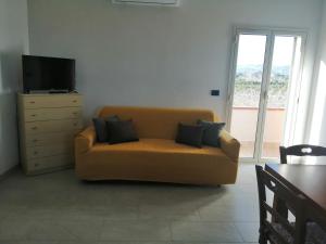 uma sala de estar com um sofá e uma televisão em Villa Caterina em Solarino