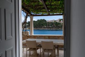 a dining room with a table and a view of the ocean at Seafront apartment Marina in Jelsa