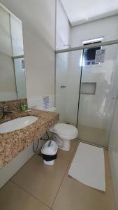 uma casa de banho com um WC, um lavatório, uma banheira e um WC. em Ribs Hotel em Piuí