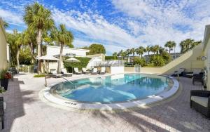 - une piscine dans une cour bordée de palmiers dans l'établissement LaPlaya 201C Breathtaking Gulf panorama from this corner end unit with a private stairway to the beach, à Longboat Key