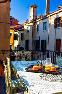 einen Tisch mit einem Tablett mit Orangen darüber in der Unterkunft La Terrazza di San Marco - Luxury Apartment in Venedig