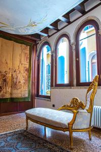ein Zimmer mit einer Bank in einem Zimmer mit Fenstern in der Unterkunft La Terrazza di San Marco - Luxury Apartment in Venedig
