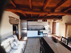 a kitchen with a couch and a table in a room at Casa alla Fontana in Faggeto Lario 