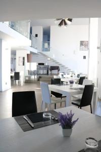 a dining room with white tables and chairs at HOTEL QUADRIFOGLIO in Pomigliano dʼArco
