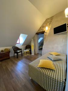 a bedroom with a bed and a tv in a attic at La Loubertine in Géanges