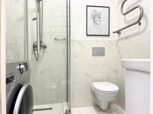 a white bathroom with a shower and a toilet at Апартаменты #3 in Almaty