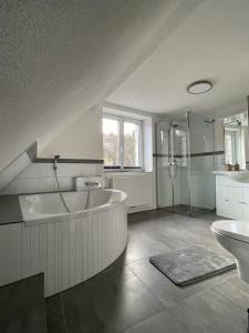 een grote badkamer met een bad en een wastafel bij Kaffeevollautomat, Hängematte & Netflix, zentral in Idar-Oberstein