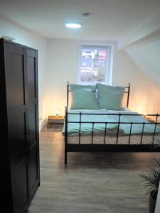 een slaapkamer met een bed met groene kussens en een raam bij Kaffeevollautomat, Hängematte & Netflix, zentral in Idar-Oberstein