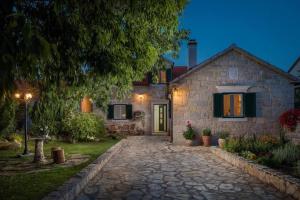 Villa Giardino في Drinovci: منزل حجري أمامه مسار حجري