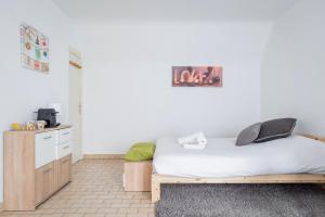 um quarto com uma cama e uma secretária. em Petit Cronenbourg - GOLDEN TREE - WIFI - 5 min gare de Strasbourg em Estrasburgo