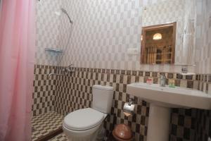 La salle de bains est pourvue de toilettes et d'un lavabo. dans l'établissement Margiana, à Samarcande