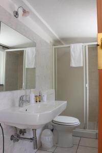 bagno con lavandino, servizi igienici e specchio di Villa Valentina Park a Posada
