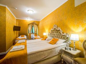 サノクにあるROYAL PALACE Centrum Bankietoweの黄色の壁のホテルルーム(大型ベッド付)