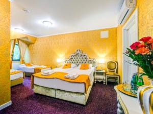 pokój hotelowy z 2 łóżkami i żółtymi ścianami w obiekcie ROYAL PALACE Centrum Bankietowe w mieście Sanok +26 zdjęć