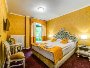 a bedroom with a bed and a table and a chair at ROYAL PALACE Centrum Bankietowe in Sanok