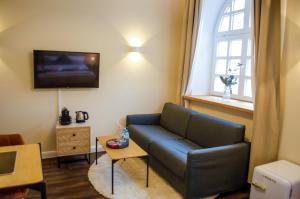 a living room with a blue couch and a tv at HOMELY STAY Studio 3 in Munich