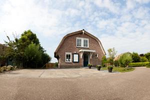 een stenen huis met een rieten dak bij Het Eerste Huisje vacation home in Noordwijk aan Zee