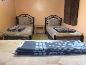 a room with two beds with blue and white blankets at Auberge lac d'ifni in Aoulouz