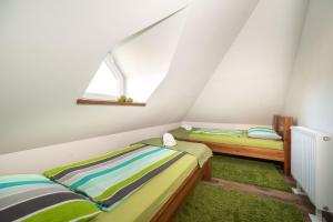 two twin beds in a room with a window at Juhar Apartmanház in Balatongyörök