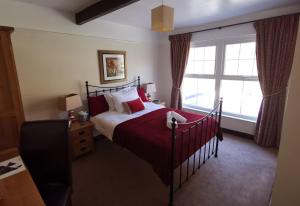 a bedroom with a bed and a large window at The Langstrath Country Inn in Keswick