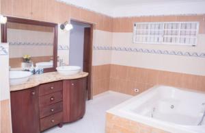 a bathroom with two sinks and a bath tub at Penthouse con jacuzzi La cueva de los 3 ojos in Santo Domingo