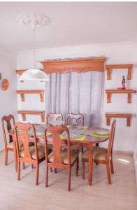 a dining room with a wooden table and chairs at Penthouse con jacuzzi La cueva de los 3 ojos in Santo Domingo