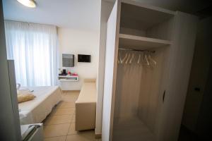 Habitación con puerta a un dormitorio con cama en Hotel ABC, en Riccione