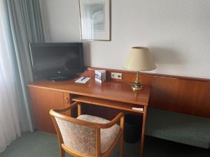 a desk with a television and a lamp on it at Haus Im Garten in Köngen