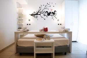 a bedroom with a bed with a branch on the wall at Hotel ABC in Riccione +57 photos