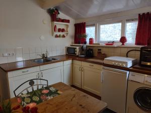a small kitchen with a table and a sink at STRANDGAPER Bed by the Sea in Westkapelle