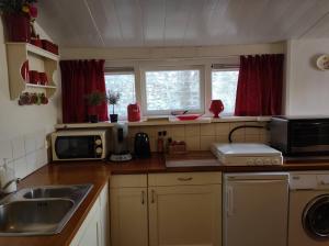 a kitchen with a sink and a microwave at STRANDGAPER Bed by the Sea in Westkapelle