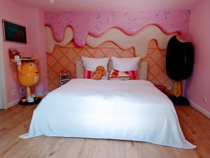 ein Schlafzimmer mit einem weißen Bett in einem rosa Zimmer in der Unterkunft Candypartment Sweets 'n Sleep in Gelsenkirchen