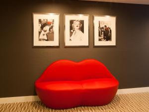 a red couch sitting in front of a wall at Lutecia Smart Design Hotel in Lisbon