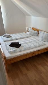 2 große Betten in einem Zimmer mit Holzböden in der Unterkunft Pension Souchon in Borkum
