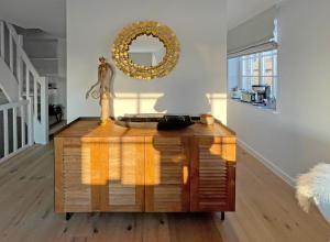 a dresser in a room with a mirror on the wall at Wattteufel Sylt in Rantum