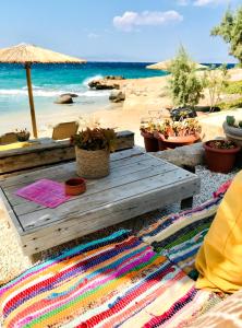 una mesa de picnic en una playa con vistas al océano en The Beachhouse Apartments, en Vagia