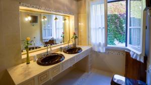 a bathroom with two sinks and a large window at Welcomely - Residenza Deriu in Bosa