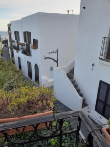 un edificio bianco con scale e piante su un balcone di casa u turcu a Stromboli
