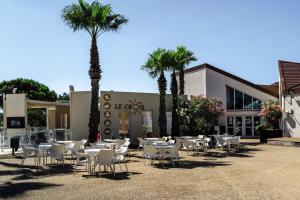 a group of tables and chairs in front of a building at Belambra Clubs Résidence Gruissan - Les Ayguades in Gruissan