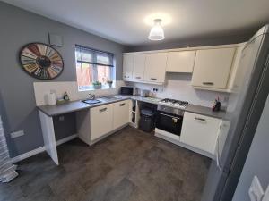 a kitchen with white cabinets and a counter top at Delightful 3 bed house nr the centre of Cheltenham in Cheltenham