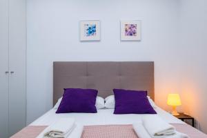 1 dormitorio con 1 cama grande con almohadas moradas en Brand New Apartment With Super Comfortable Beds 3 en Valencia