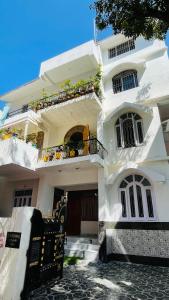 Uma casa branca com um banco à frente. em Krishna Kunj em Rānchī