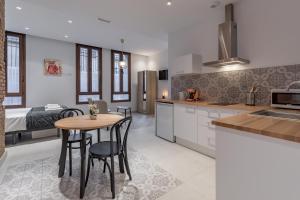 a kitchen and living room with a table and chairs at Gorgeous Apartment close to City Centre in Valencia