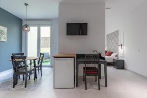 Chic & Comfortable Apartment, Private Terrace في فالنسيا: مطبخ وغرفة طعام مع طاولة وكراسي